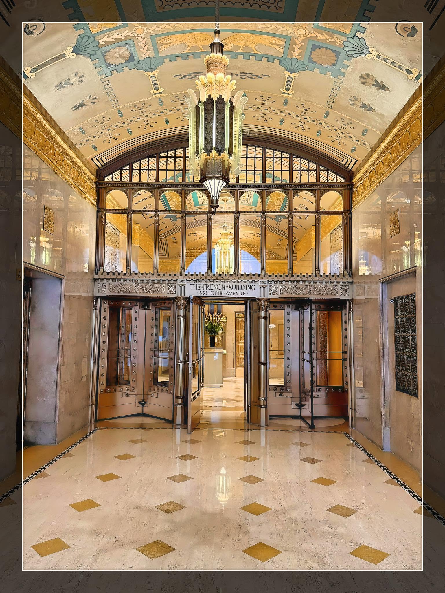 The Art Deco lobby of the French Building at 551 Fifth Avenue, its bronze doors and chandelier gleaming.