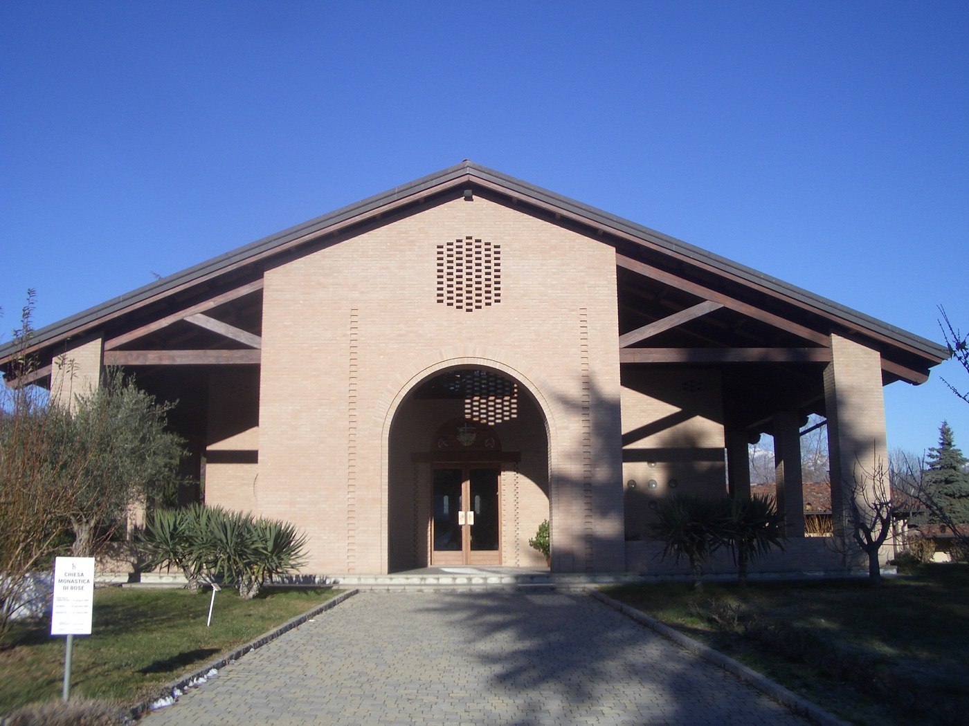 Front of the monastery church with "COMUNITÀ DI BOSE" gate sign