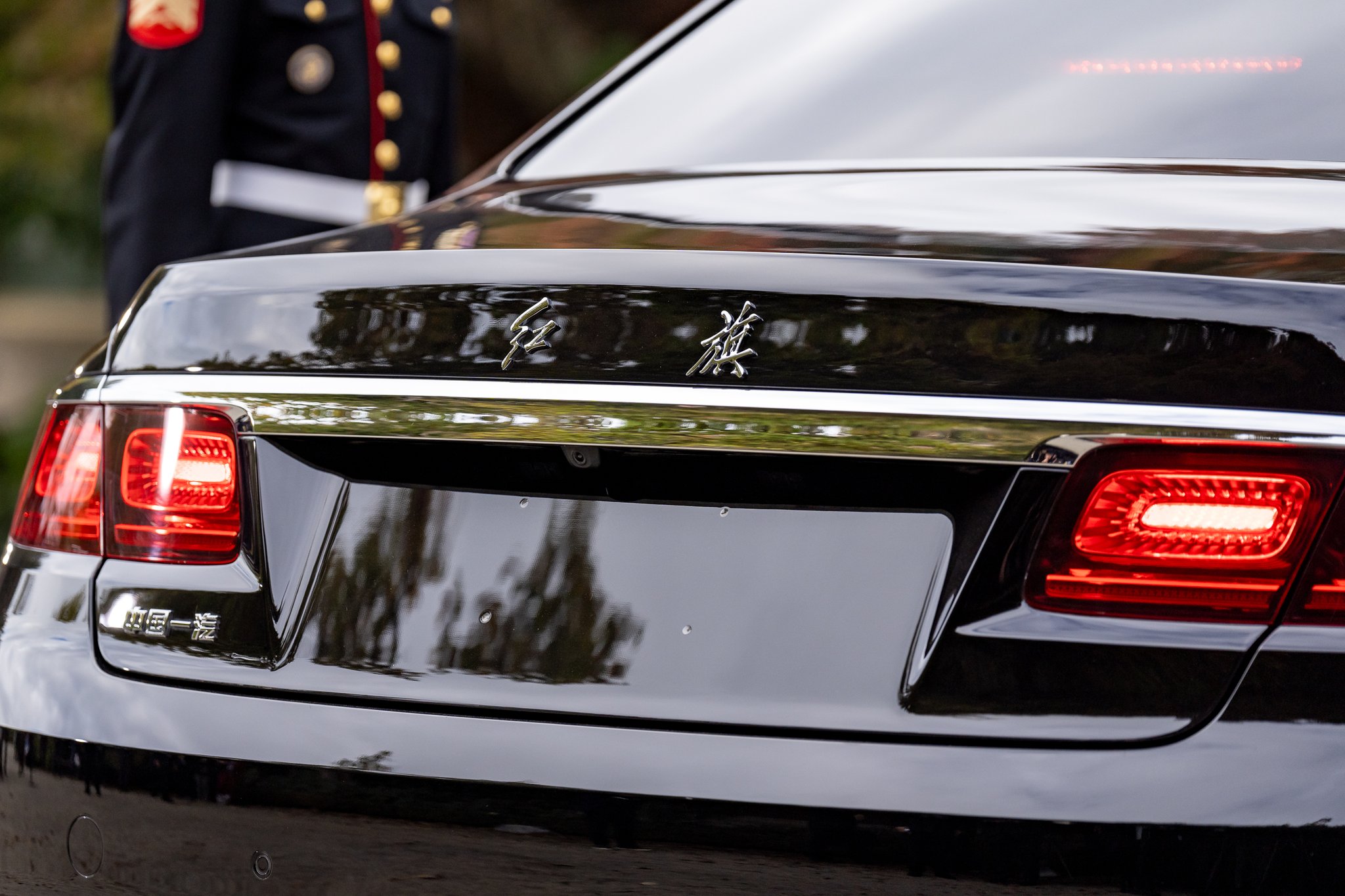 Filoli, Woodside, California, November 15, 2023: the rear of the Chinese state car, with "红旗" (Hongqi) in chrome script and the "中国一汽" (China FAW) badge, its lamps glowing red.