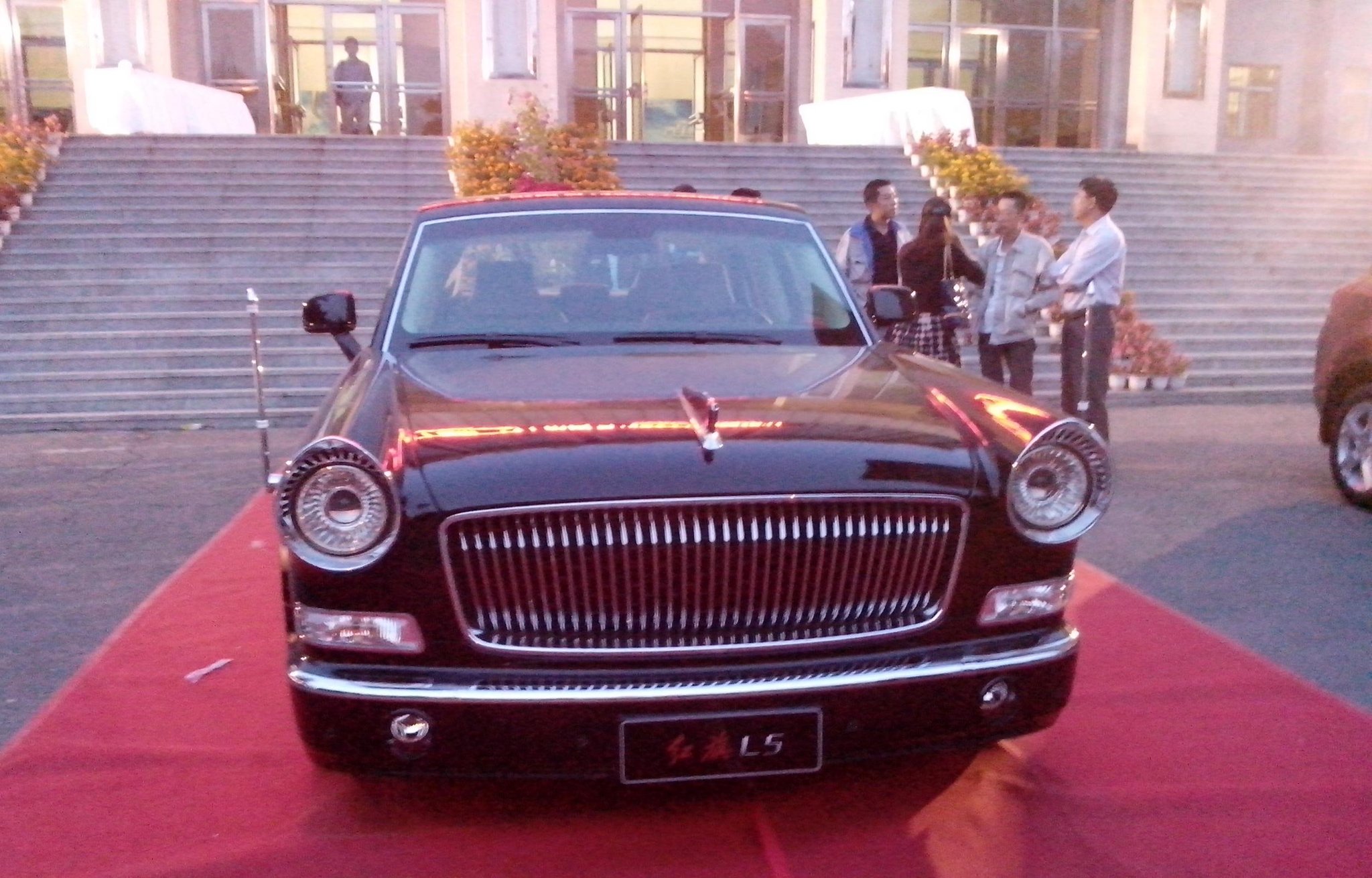 The Hongqi L5, a modern limousine whose round lamps and vertical grille recall the classic state cars, on a red carpet in 2013.