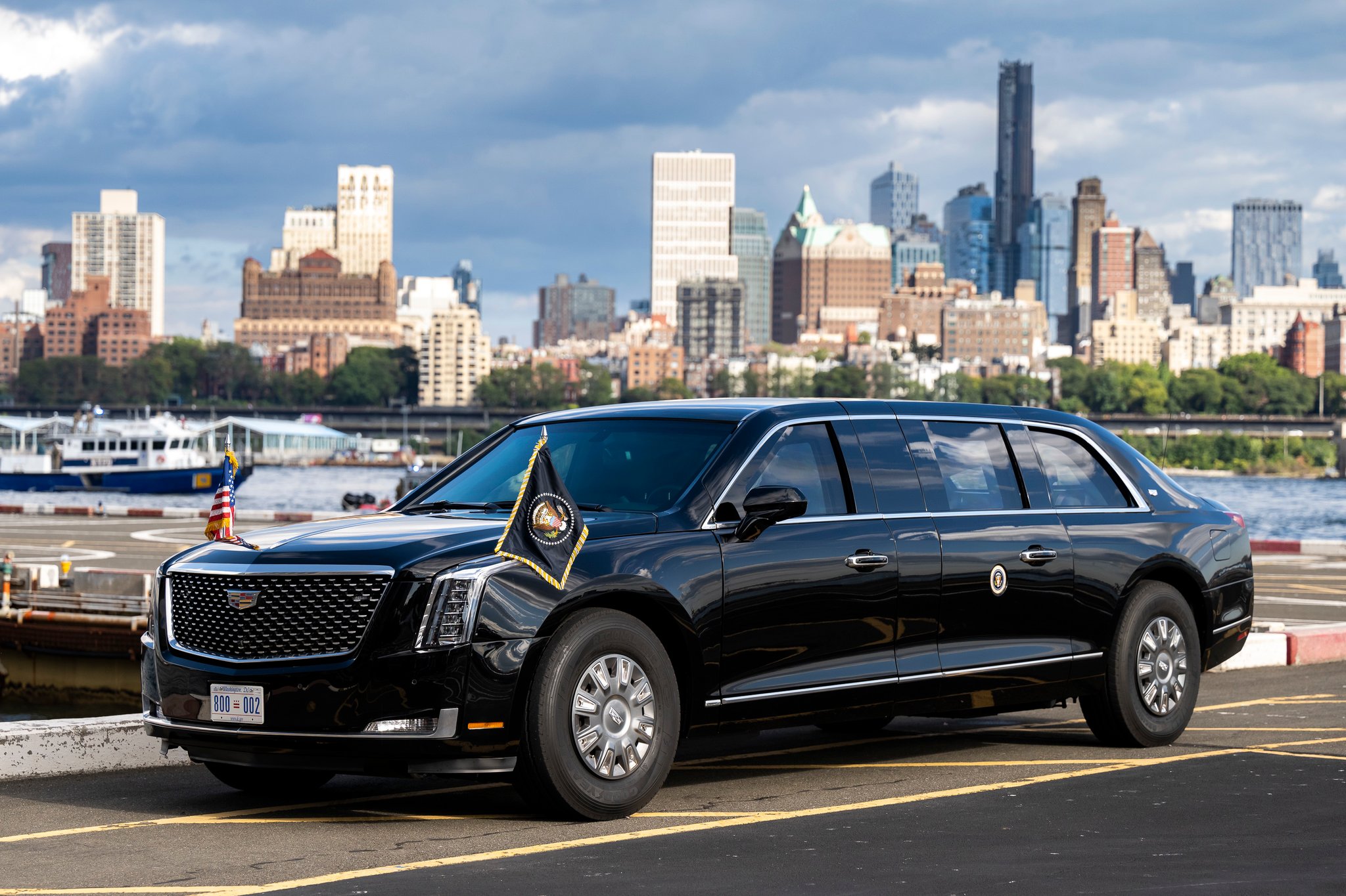 The presidential limousine, flags mounted on its fenders, at a landing zone with the New York skyline behind it, September 2022.