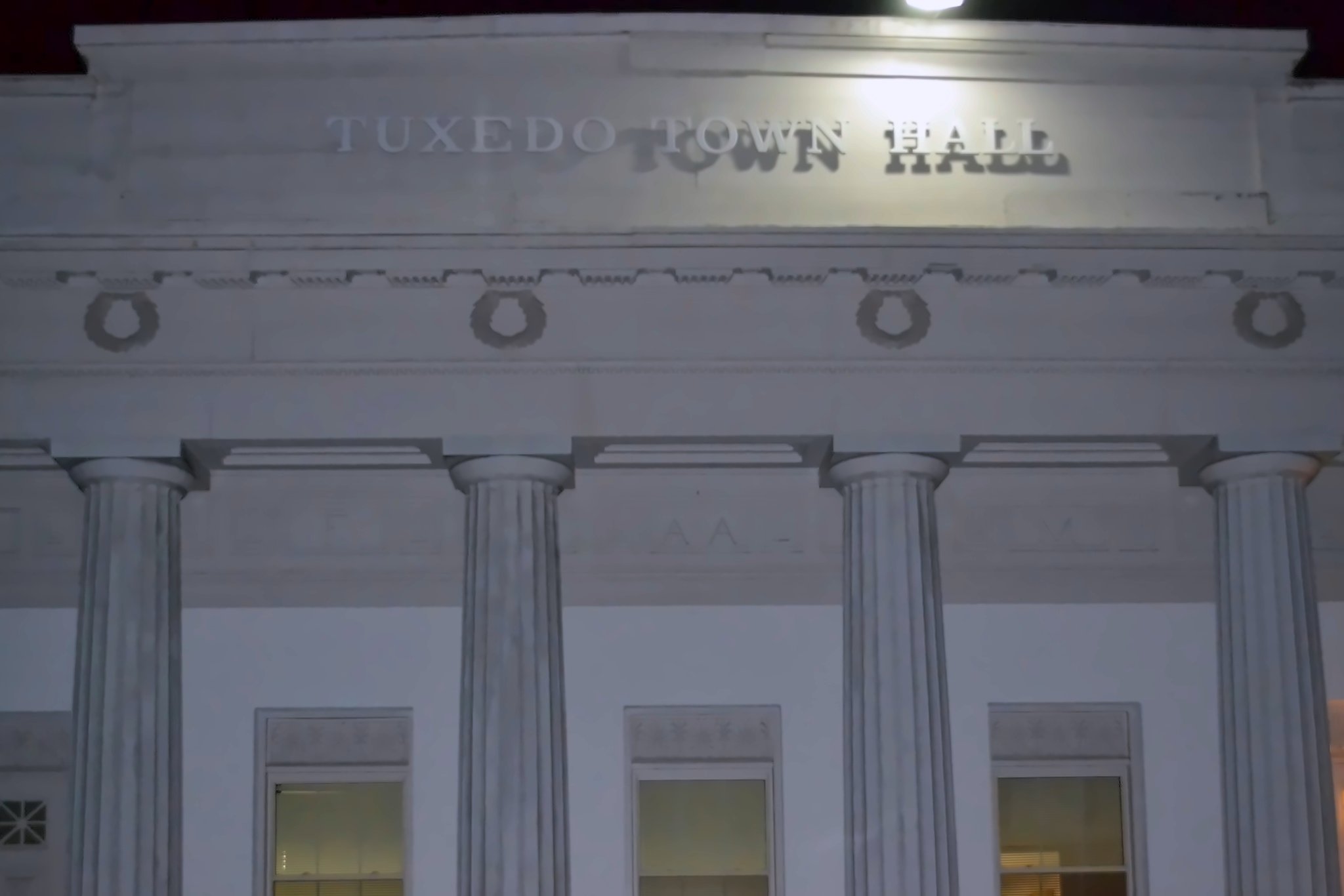Carved lettering on a classical entablature, above columns, reads TUXEDO TOWN HALL.